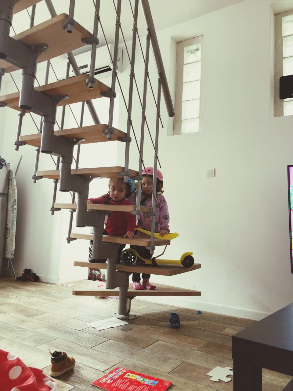 Des artisans rénovent le salon d’une maison habitée tandis que les meubles sont protégés par des bâches.